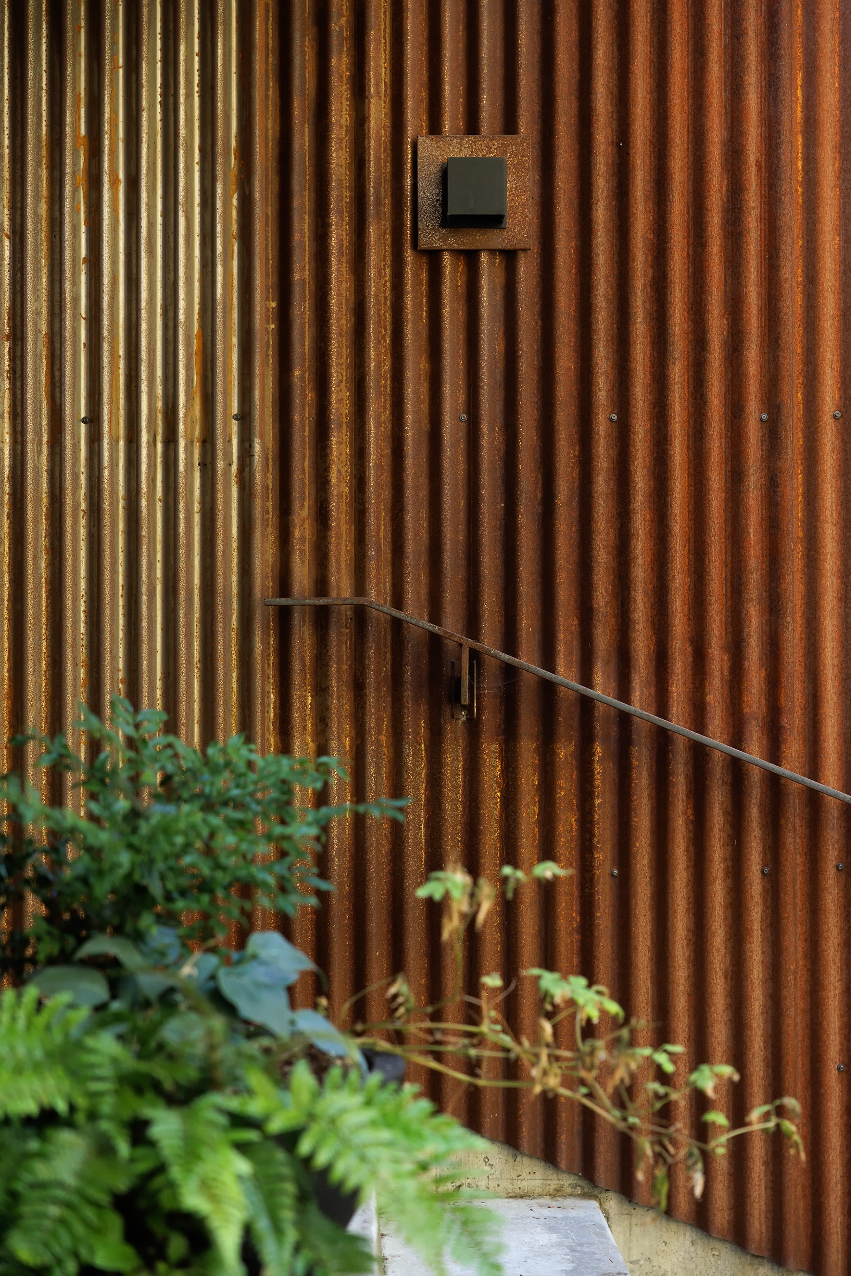 Broadwell Metal exterior corrugated petina finish siding with railing